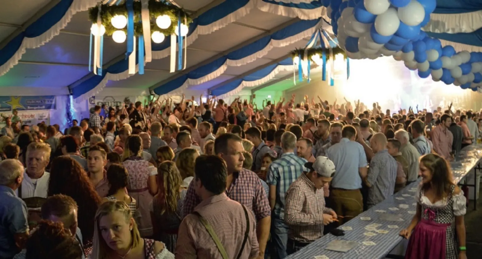 Volles Festzelt beim Oktoberfest Vierbuchermühle: Gäste in Tracht unter blau-weißer Zeltdekoration
